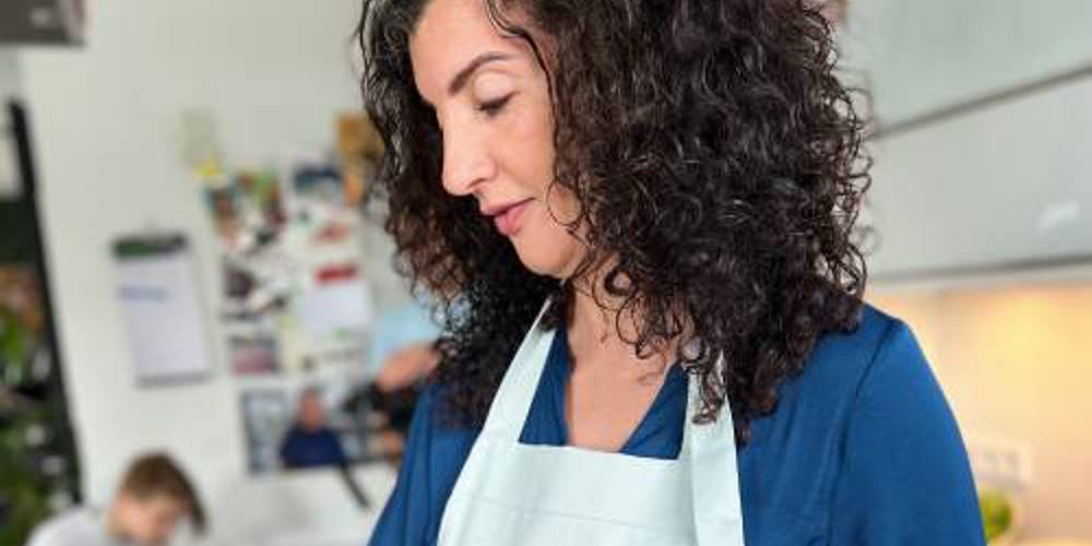 Nadia Zerouali snijdt groenten in keuken met schort 'beste bordje'.