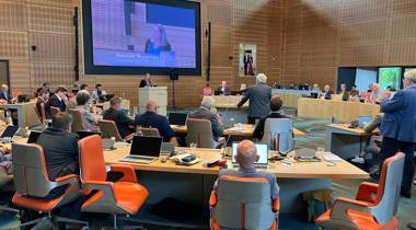 De Statenvergadering van 9 juli. Op het grote scherm staat "Renilde Huizenga – Fractievoorzitter D66.