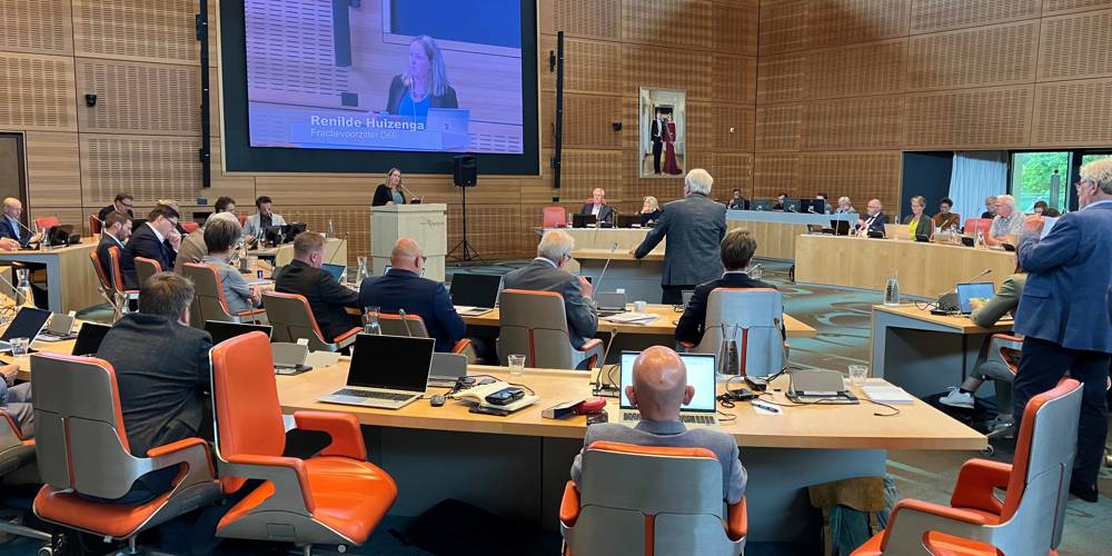 De Statenvergadering van 9 juli. Op het grote scherm staat "Renilde Huizenga – Fractievoorzitter D66.