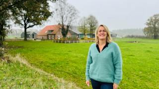 Frederiek van Lienen poseert in weiland voor boerderij