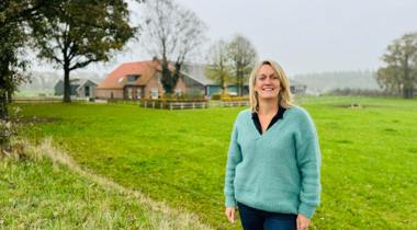 Frederiek van Lienen poseert in weiland voor boerderij