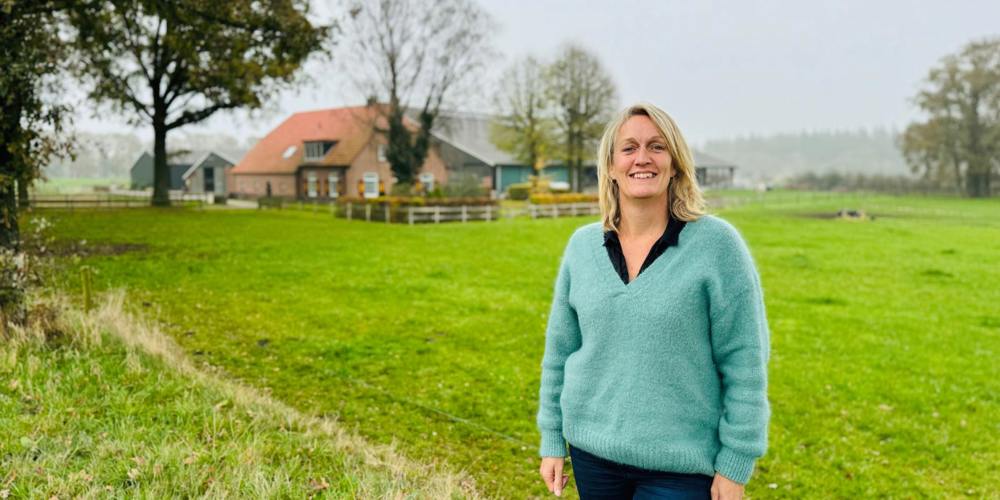Frederiek van Lienen poseert in weiland voor boerderij