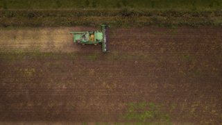 Luchtfot van akker met traktor.