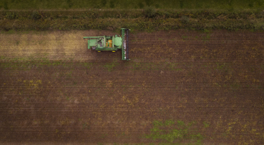 Luchtfot van akker met traktor.