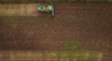 Luchtfot van akker met traktor.