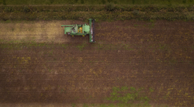 Luchtfot van akker met traktor.